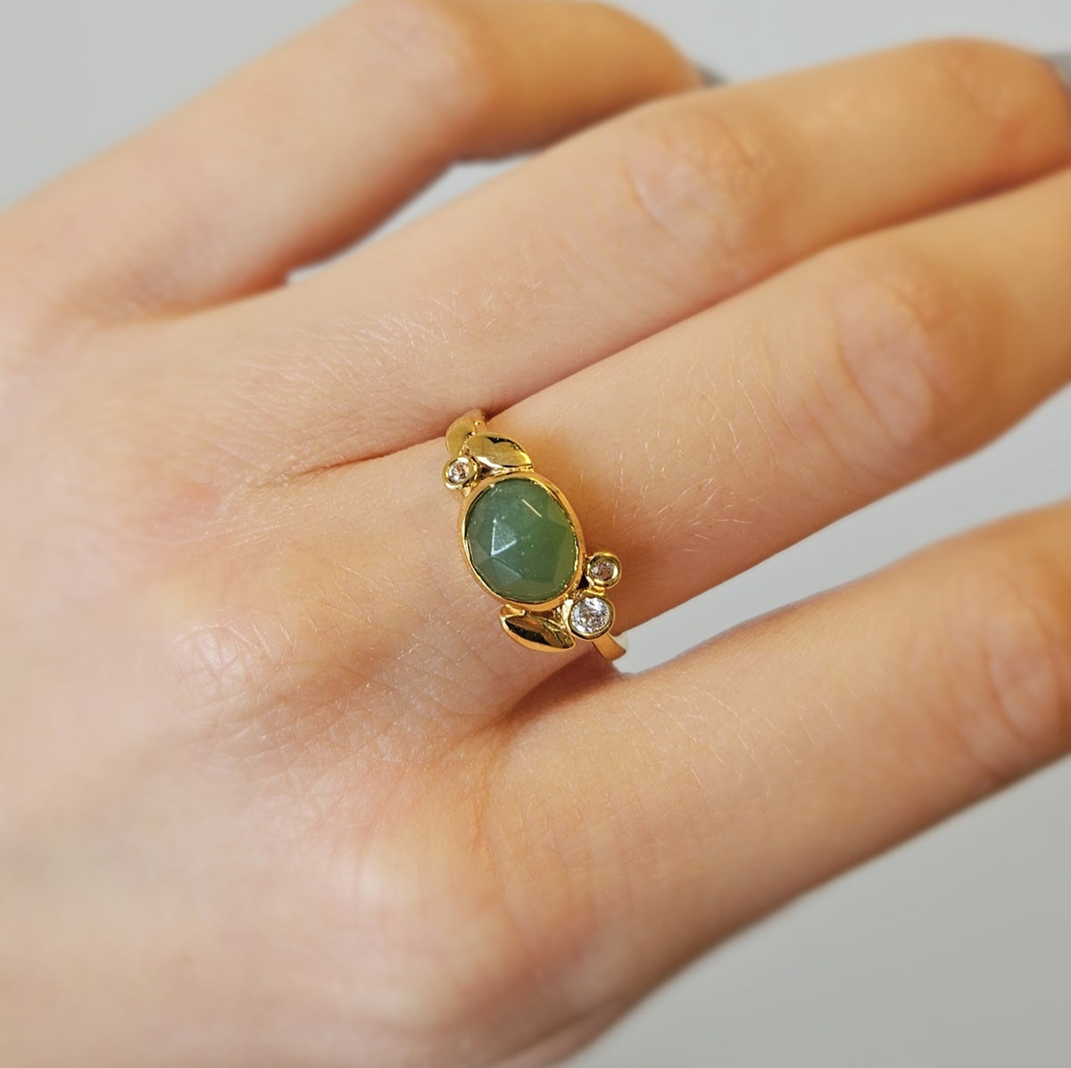 Rabinovich Bliss ring i forgyldt sølv med grøn serpentin og zirkonia, liggende på flade