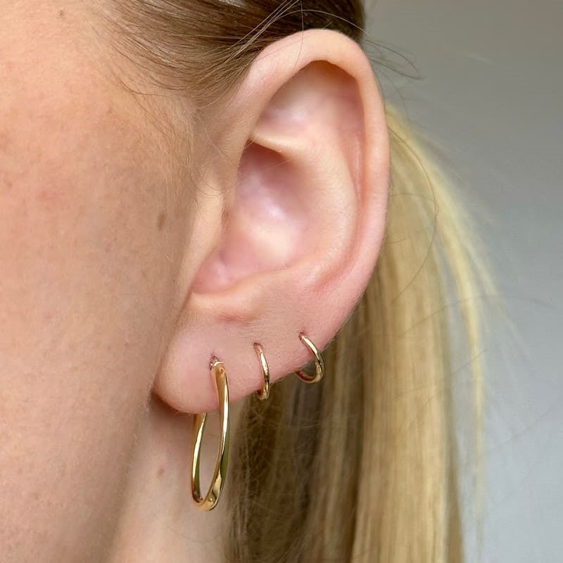 Siersbøl guldcreoler i 8 kt guld, oval drejet design – set fra siden