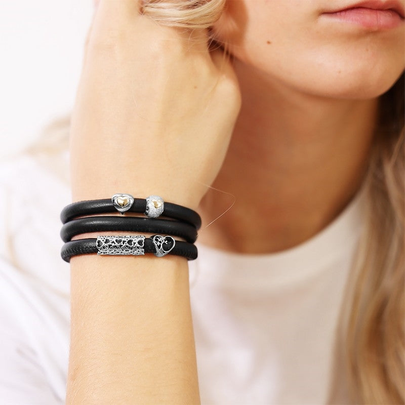 Christina Hearts Universe charm i sølv til læderarmbånd båret på model