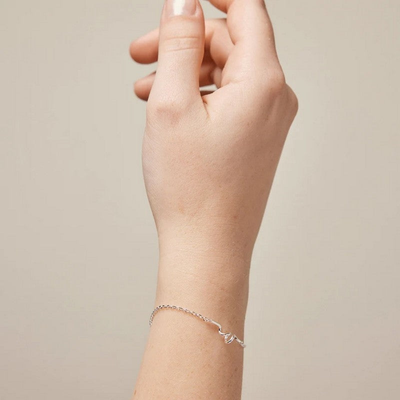 Enamel Copenhagen Twist armbånd i sterlingsølv med lyserød emaljekugle ved låsen, set fra siden