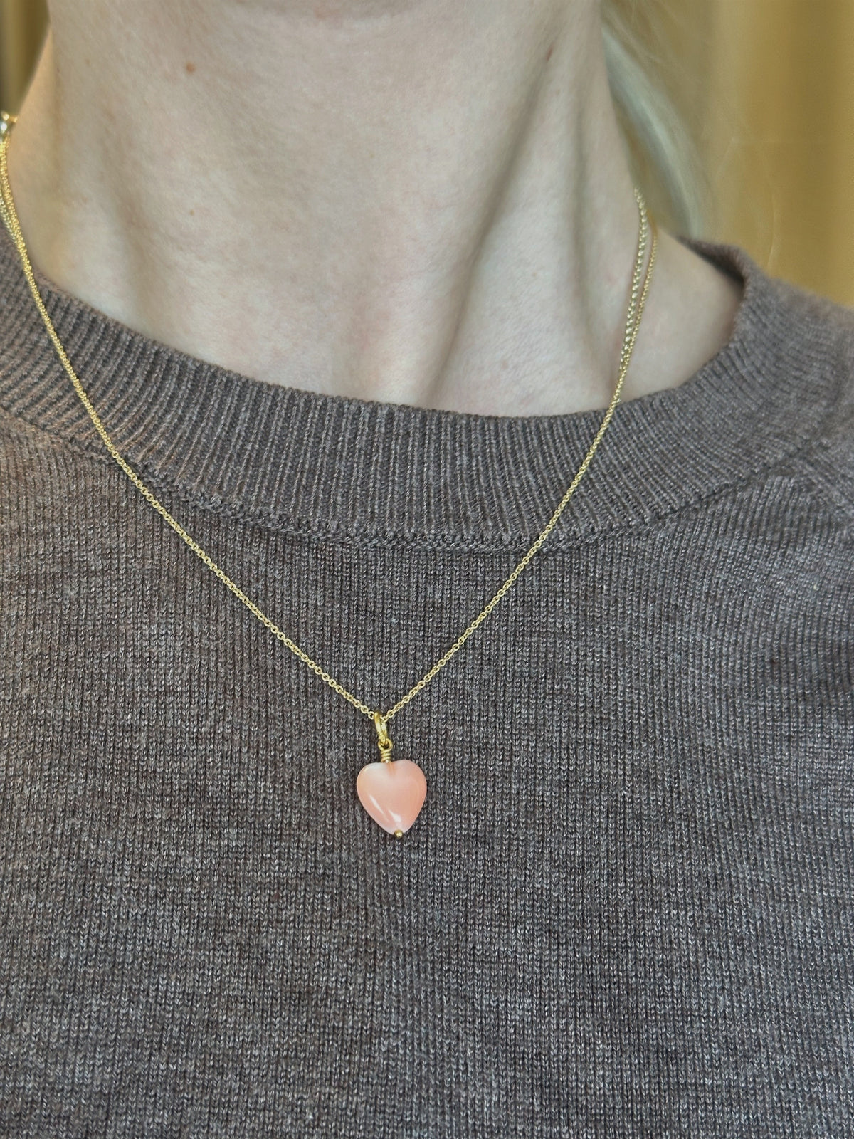 Pico Copenhagen French Heart Pendant i koralrød – guldbelagt messing hjertevedhæng liggende på flade