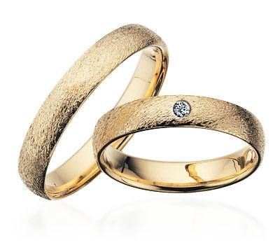 Scrouples vielsesringe i guld med rustik overflade og diamant, set fra oven