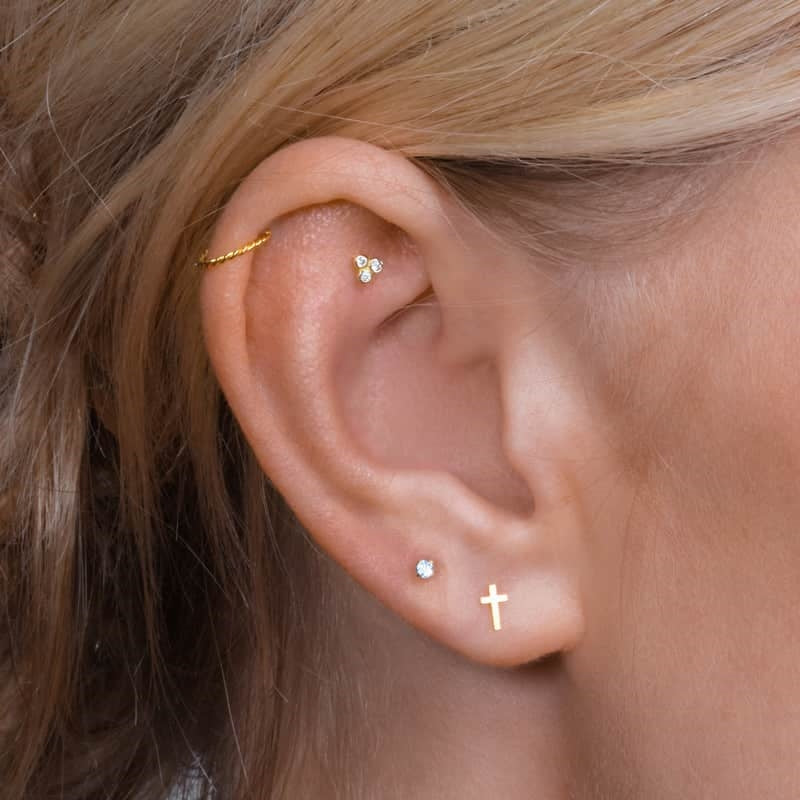 Nordahl Andersen labret-piercing kors i 14 kt. guld – nærbillede af fatning