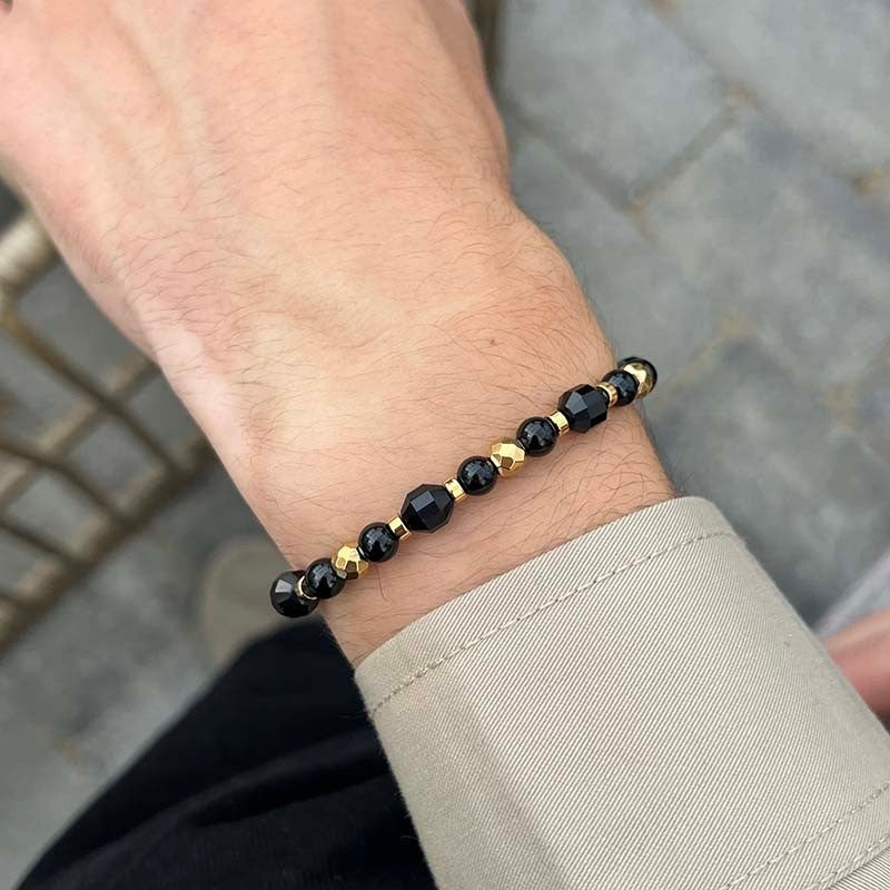 Rico's armbånd med sorte agat-perler og forgyldt stål, set fra siden
