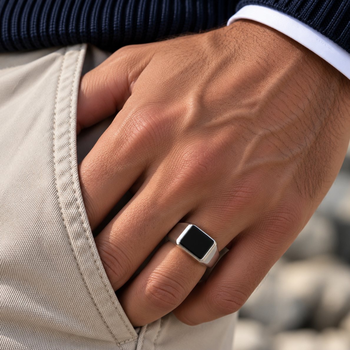 Mand med Rico's signetring i stål med sort onyx på ringfingeren og hånden i bukselommen