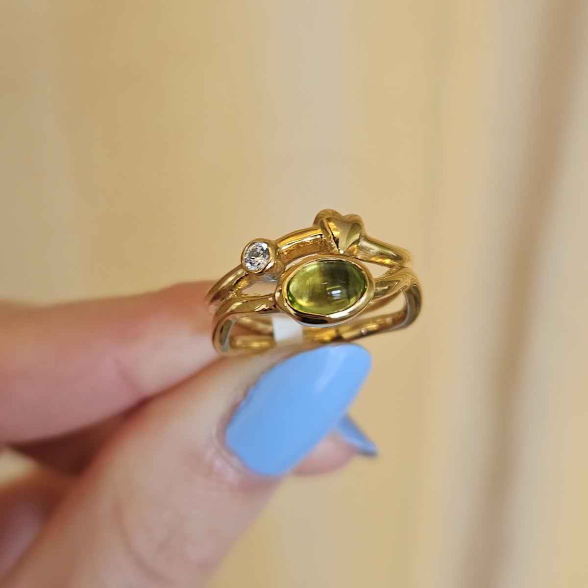 Rabinovich Rainforest Dew ring i forgyldt sølv med peridot og zirkonia, liggende på flade