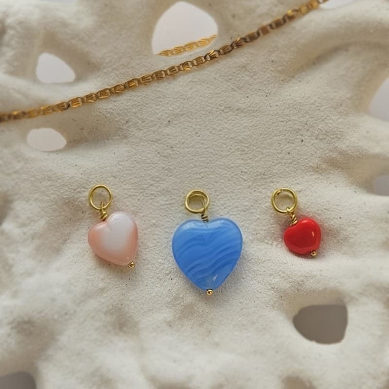 Pico Copenhagen French Heart Pendant i messing med guldbelægning og koralglas – nærbillede af sten