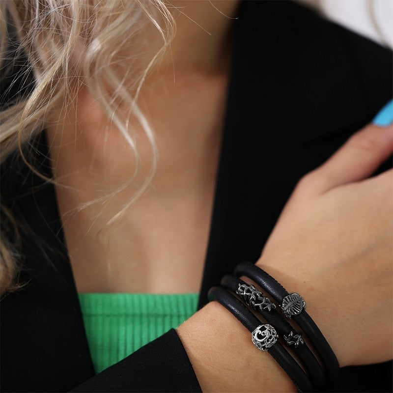 Christina Sparkling Leaf charm i sort sølv til læderarmbånd båret på model