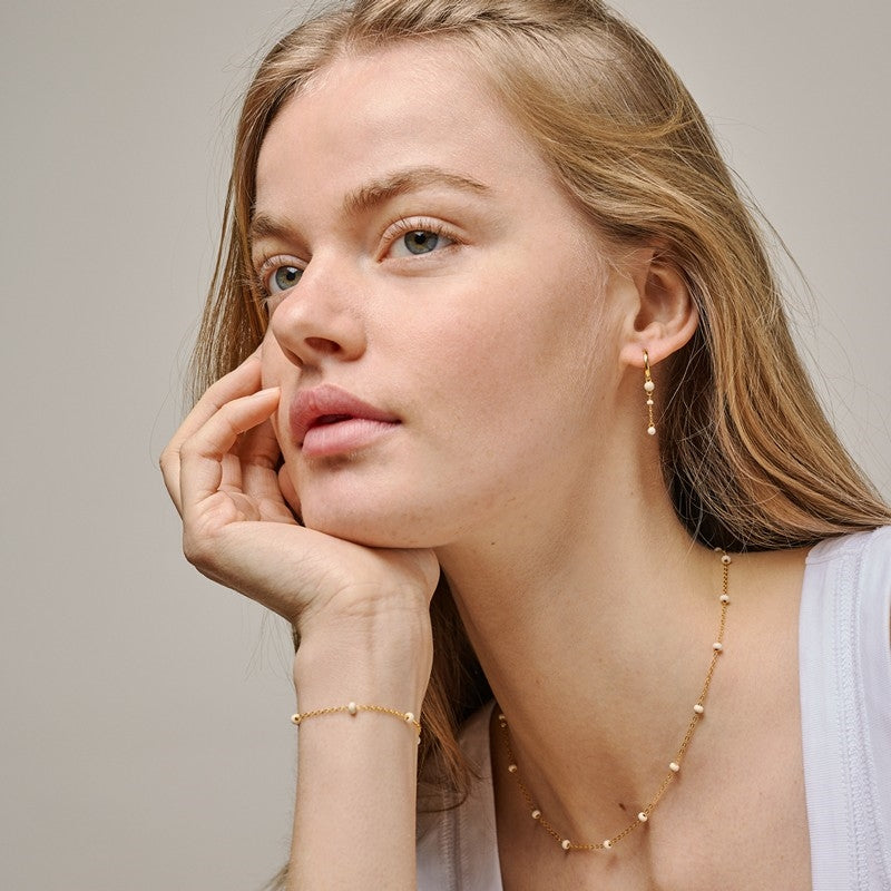 Enamel Copenhagen Lola Bold Daisy armbånd i forgyldt sølv med cremefarvede emaljekugler, set fra siden