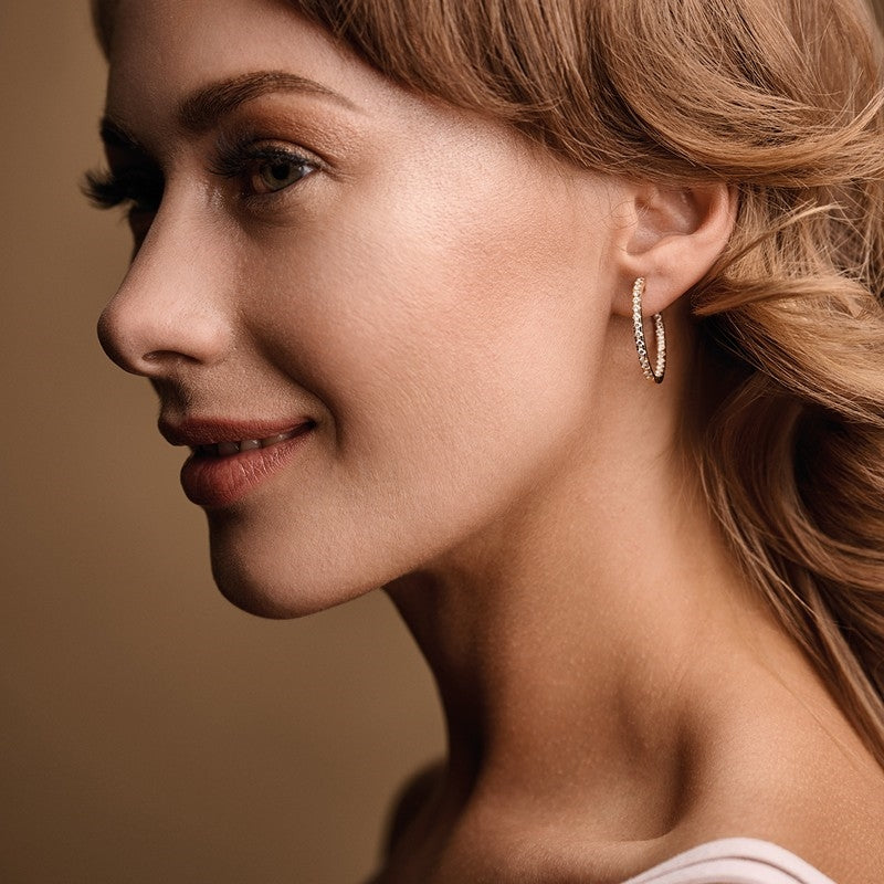 Nuran creoler i 14 karat guld med 0,60ct diamanter, set fra siden