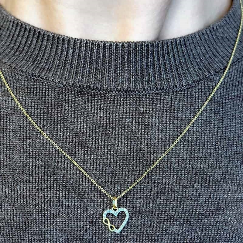 Hjertevedhæng i 8 karat guld med zirkonia og uendelighedstegn, set fra siden