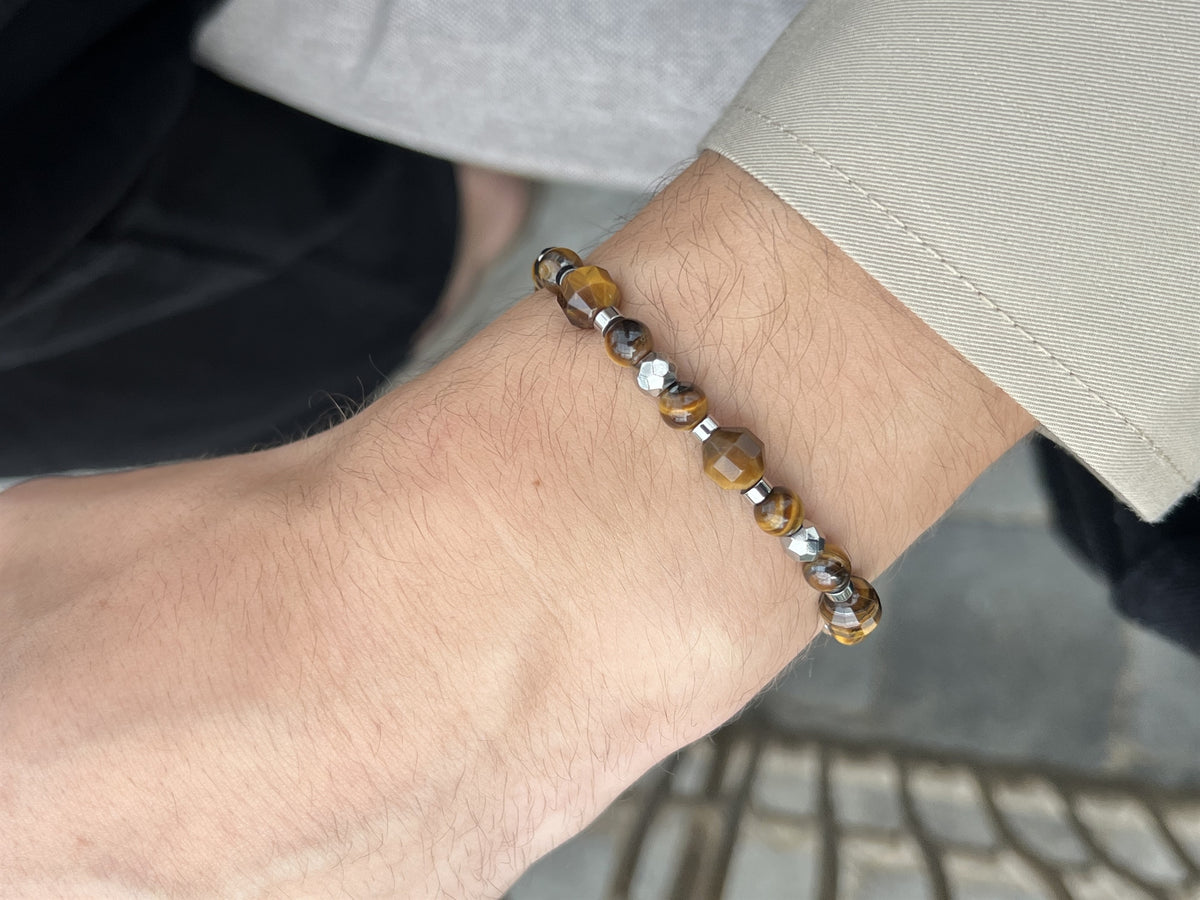 Rico's herrearmbånd i rustfrit stål med gyldne tigerøje-perler, set fra siden