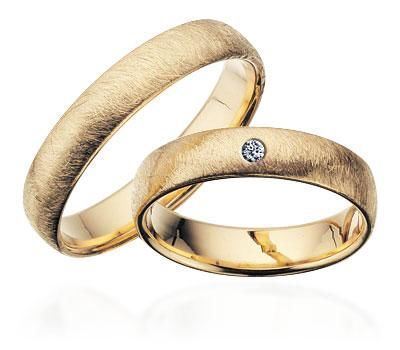 Scrouples vielsesringe i guld med frosted overflade – liggende på flade