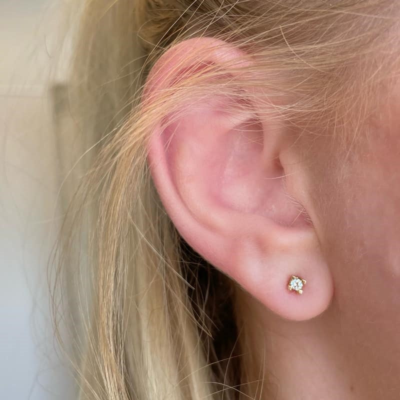 Scrouples Kleopatra ørestikker i 14 kt. guld med brillantslebne diamanter, liggende på flade