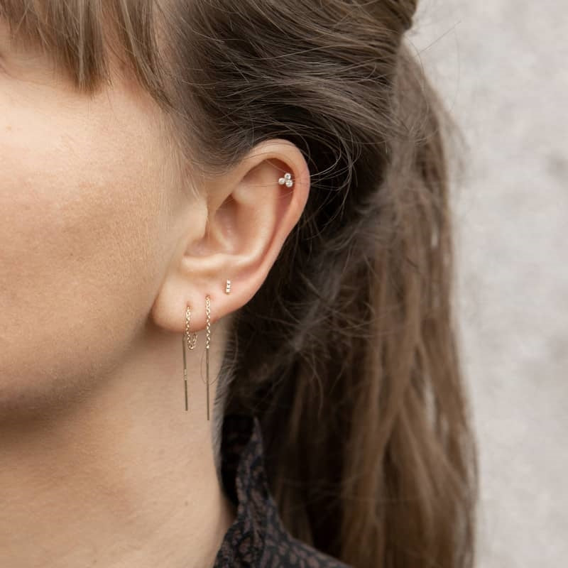 Nordahl Andersen piercing i 14 kt. guld med 3 diamanter i blomstfatning, liggende på flade