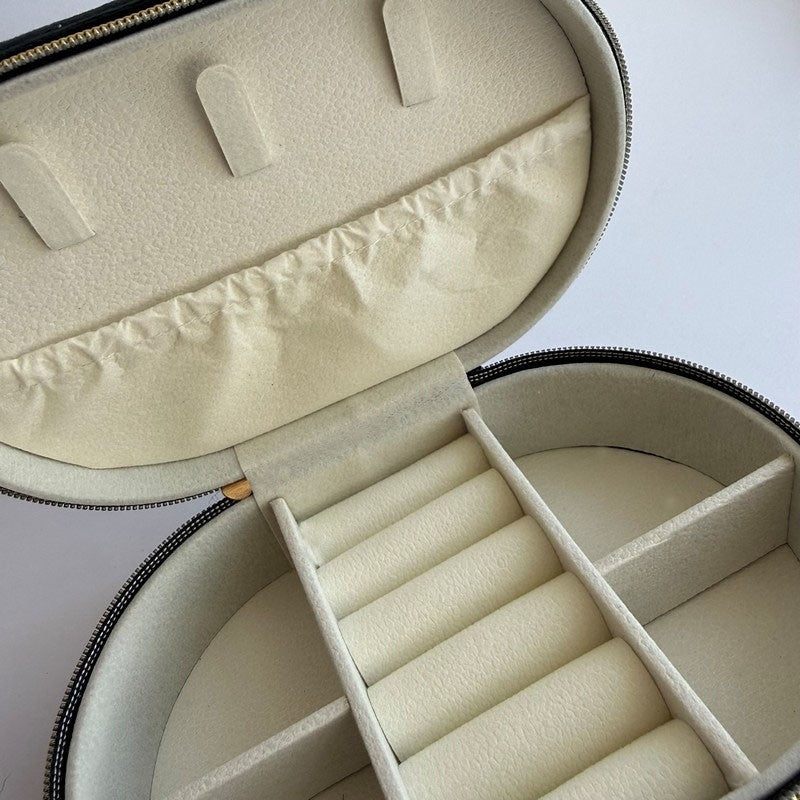 Ovalt rejsesmykkeskrin i sort velour – nærbillede af detalje