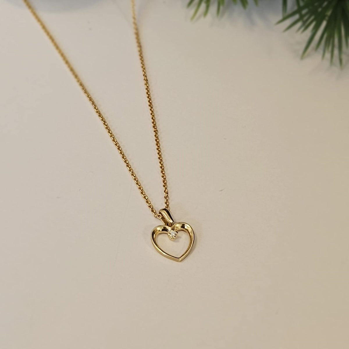 Nuran hjertehalskæde i 14 karat guld med 0,02 ct. diamant – liggende på flade