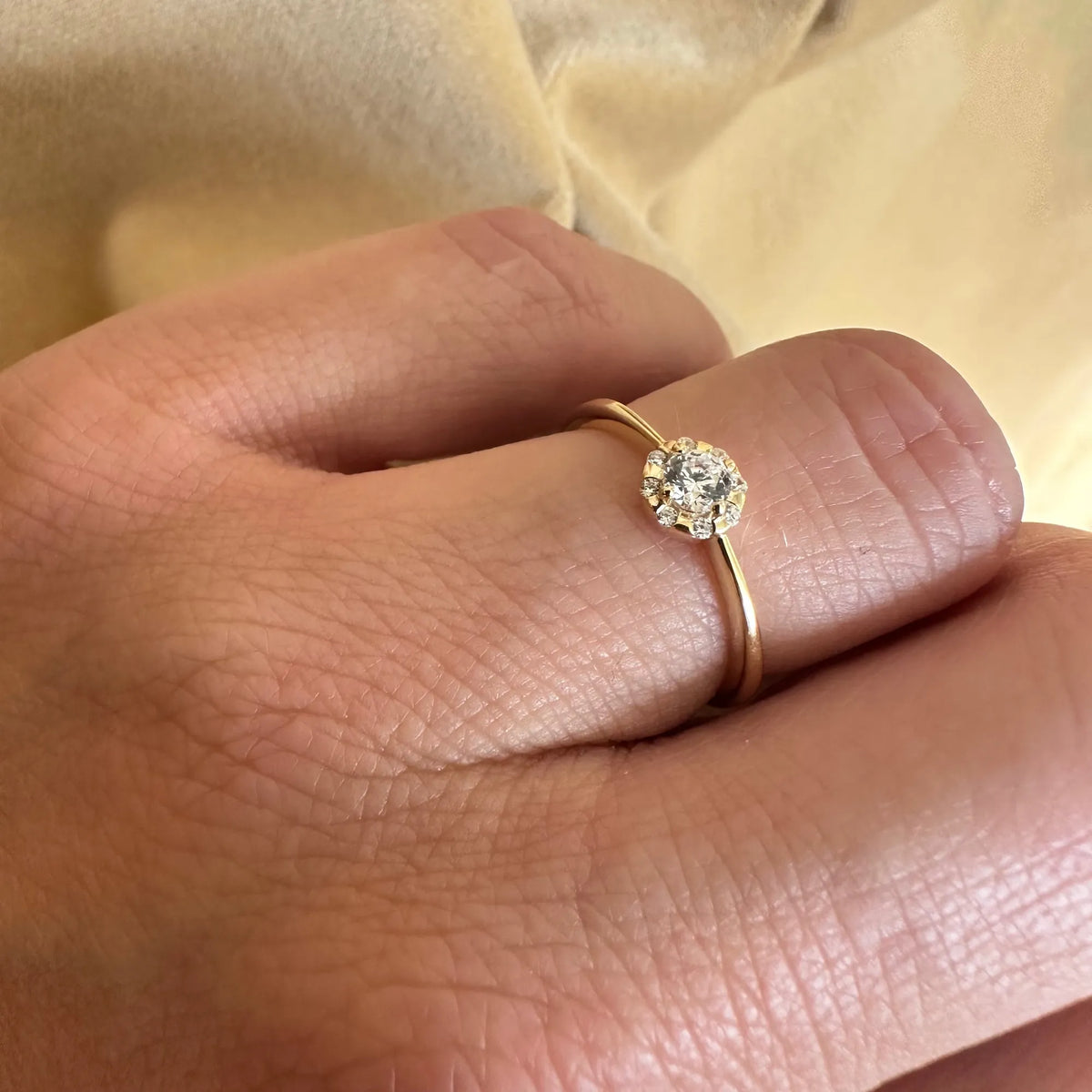 Halo ring i 8 kt guld med zirkonia båret på hånden