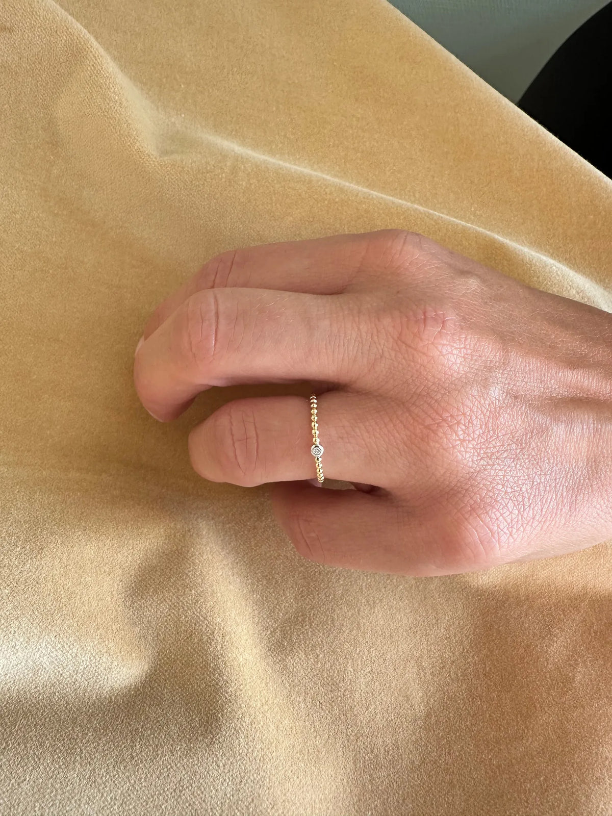 Kuglering i 14 kt guld med diamant 0,02 ct båret på hånden